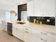 A close-up shot of a modern white kitchen featuring sleek cabinets and stylish black backsplash at 9907 Island Harbor Dr, Port Richey, FL 34668