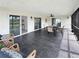 Covered patio with tiled flooring, outdoor seating, and sliding glass doors to the interior at 9907 Island Harbor Dr, Port Richey, FL 34668