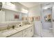 Bright bathroom featuring double sinks, granite countertops, and a walk-in shower and linen closet at 100 Bluff View Dr # 405A, Belleair Bluffs, FL 33770