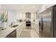 Modern white kitchen featuring stainless steel appliances, granite countertops, and a stylish backsplash at 100 Bluff View Dr # 405A, Belleair Bluffs, FL 33770