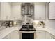 Close up of the modern white kitchen featuring stainless steel appliances, granite countertops, and backsplash at 100 Bluff View Dr # 405A, Belleair Bluffs, FL 33770