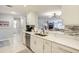 Bright kitchen featuring white cabinets, granite countertops, stainless steel appliances and open view to the living room at 100 Bluff View Dr # 405A, Belleair Bluffs, FL 33770