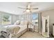 Comfortable bedroom featuring a large ceiling fan, natural light, and neutral decor at 1011 N Paddock Ave, Tampa, FL 33607