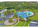 An aerial view of the community pool, playground, common area, and lush green landscaping around the property at 10415 Cardera Dr, Riverview, FL 33578