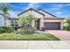 Charming single-Gathering home featuring a two-car garage, stone accents, and mature landscaping at 10415 Cardera Dr, Riverview, FL 33578
