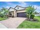 Beautiful home with lush landscaping, a brick driveway, and a well-maintained lawn at 10415 Cardera Dr, Riverview, FL 33578