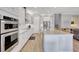 Modern kitchen featuring stainless steel appliances, white cabinets, light countertops, and hardwood floors at 10415 Cardera Dr, Riverview, FL 33578