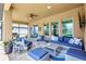 Comfortable covered patio featuring stylish seating, ceiling fan, and views of the backyard and nearby pond at 10415 Cardera Dr, Riverview, FL 33578