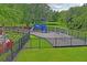 A fenced-in community playground featuring slides, swings, and climbing structures surrounded by lush green landscaping at 10415 Cardera Dr, Riverview, FL 33578