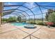 Backyard oasis showcasing a screened-in pool and hot tub, surrounded by lush landscaping and pond views at 10415 Cardera Dr, Riverview, FL 33578