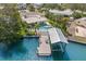 Aerial view features a dock, swimming pool and well maintained landscaping along the canal at 106 Midway Is, Clearwater Beach, FL 33767