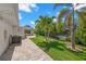 Spacious backyard with well-maintained lawn, mature trees, and partial view of the pool at 106 Midway Is, Clearwater Beach, FL 33767