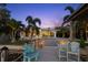A waterfront home featuring a dock, pool, and outdoor seating area with lush landscaping and sunset views at 106 Midway Is, Clearwater Beach, FL 33767