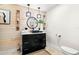 Stylish powder room with black vanity, modern lighting, and decorative accents at 106 Midway Is, Clearwater Beach, FL 33767