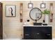 Chic bathroom with black vanity, quartz countertop, wood paneling, and decorative accents at 106 Midway Is, Clearwater Beach, FL 33767
