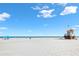 Expansive beach view with white sand, blue sky, lifeguard tower, and the ocean in the distance at 106 Midway Is, Clearwater Beach, FL 33767