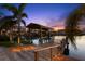 Waterfront home featuring a private dock with boat lift, covered seating area, and stunning sunset views at 106 Midway Is, Clearwater Beach, FL 33767