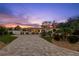 Beautifully landscaped home exterior with a long, patterned brick driveway at sunset at 106 Midway Is, Clearwater Beach, FL 33767