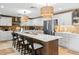 Modern kitchen features large island with seating, stainless steel appliances, and stone tile flooring at 106 Midway Is, Clearwater Beach, FL 33767