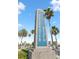Clearwater Beach sign surrounded by palm trees under a clear blue sky, marking the entrance to the iconic beach at 106 Midway Is, Clearwater Beach, FL 33767