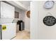 Well-equipped laundry area features a stacked washer/dryer, mini-fridge, and decorative elements at 106 Midway Is, Clearwater Beach, FL 33767