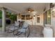 Cozy outdoor patio with a dining table, chairs, ceiling fan, grill, and comfortable rocking chairs for lounging at 106 Midway Is, Clearwater Beach, FL 33767