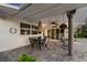 A covered patio with a dining table and chairs, ceiling fan, and elegant columns, perfect for outdoor dining at 106 Midway Is, Clearwater Beach, FL 33767