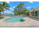 Sparkling pool area with steps and waterfront views surrounded by lush landscaping at 106 Midway Is, Clearwater Beach, FL 33767