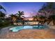 Backyard pool with palm trees and a private dock, perfect for enjoying waterfront living at 106 Midway Is, Clearwater Beach, FL 33767