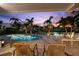 Cozy backyard pool area with seating, a private dock, and waterfront views at dusk at 106 Midway Is, Clearwater Beach, FL 33767