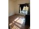 Bedroom featuring laminate flooring, a window with blinds and an unorganized closet area at 1118 E Linebaugh Ave, Tampa, FL 33612