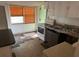 Dated kitchen with linoleum floors, white cabinetry and a window letting in natural light at 1118 E Linebaugh Ave, Tampa, FL 33612