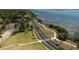Aerial view of a long road along the waterfront with lush green lawns and palm trees at 1126 Tarridon Ct, Dunedin, FL 34698