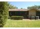 Exterior view of the home showing a well-manicured lawn and screened in porch at 1126 Tarridon Ct, Dunedin, FL 34698