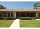 Inviting single-story home with a well-manicured lawn and a charming, screened-in front porch at 1126 Tarridon Ct, Dunedin, FL 34698