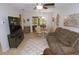 Comfortable living room featuring tile flooring, a ceiling fan, and a view into the sun room at 1126 Tarridon Ct, Dunedin, FL 34698