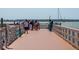 Outdoor view of a long wooden pier full of people looking at the sailboats in the bay at 1126 Tarridon Ct, Dunedin, FL 34698