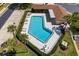 Aerial view of the sparkling community pool, surrounded by lounge chairs, umbrellas and lush landscaping at 1126 Tarridon Ct, Dunedin, FL 34698