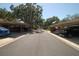 Street view of condo complex with carports, mature trees, and neatly maintained landscaping at 1126 Tarridon Ct, Dunedin, FL 34698