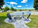 Lakeside backyard featuring an outdoor firepit with seating, perfect for entertaining guests at 1147 Halapa Way, Trinity, FL 34655