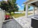 Pavered patio with a landscaped backyard featuring a tranquil lake view and a cozy fire pit at 1147 Halapa Way, Trinity, FL 34655