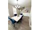Dining room boasting a marble table, blue velvet chairs, and contemporary decor at 1147 Halapa Way, Trinity, FL 34655