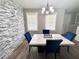 Bright dining room features stone accent wall, chandelier lighting, and marble table at 1147 Halapa Way, Trinity, FL 34655