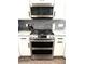 Updated kitchen features stainless steel range, microwave, and gray subway tile at 1147 Halapa Way, Trinity, FL 34655