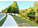 Scenic walking path along a waterway, bordered by trees and well-maintained landscaping at 1147 Halapa Way, Trinity, FL 34655
