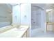 Bright bathroom featuring a white vanity, tiled floors, and a shower-tub combo with a curved shower rod at 12846 Tallowood Dr, Riverview, FL 33569