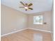 Bedroom featuring neutral walls, hardwood floors, a ceiling fan, and a bright window at 12846 Tallowood Dr, Riverview, FL 33569