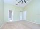 Green painted bedroom featuring neutral carpet, bright white trim, and two closet doors at 12846 Tallowood Dr, Riverview, FL 33569
