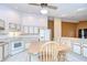 Well-lit eat-in kitchen featuring white cabinets, tile flooring, and seamlessly connecting to another room at 12846 Tallowood Dr, Riverview, FL 33569