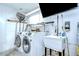 Efficient laundry room with washer, dryer, utility sink, and storage, making chores convenient and organized at 12846 Tallowood Dr, Riverview, FL 33569